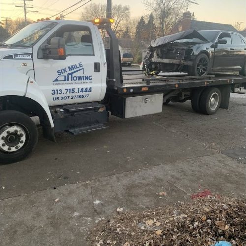 car on the back of a Six Mile Towing tow truck