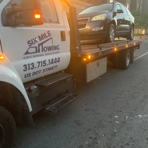 car on the back of a Six Mile Towing tow truck