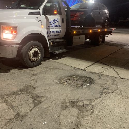 car on the back of a Six Mile Towing tow truck